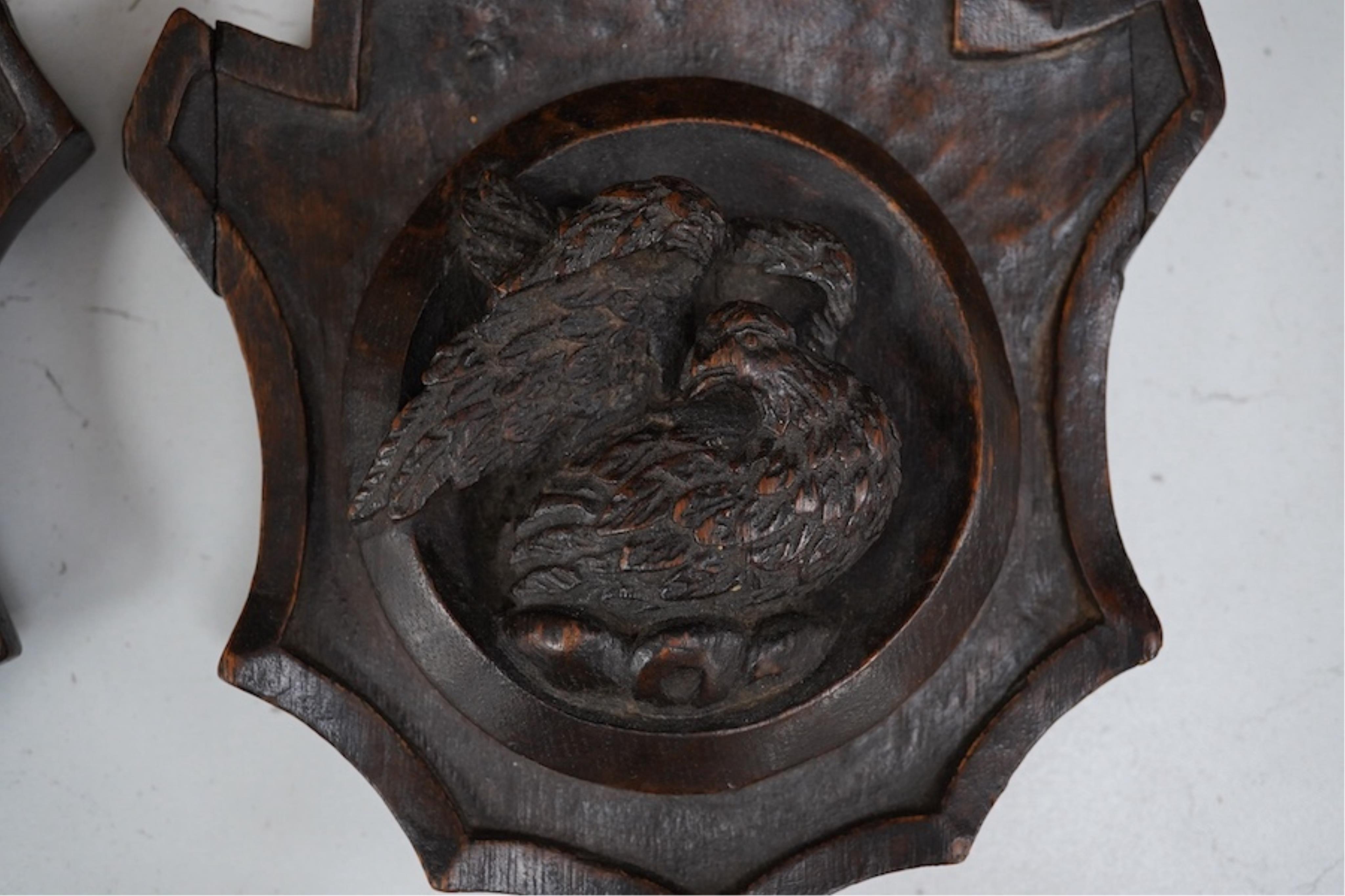 A pair of 19th century carved oak shields, one of an angel the other an eagle. 19.5cm high. Condition - good